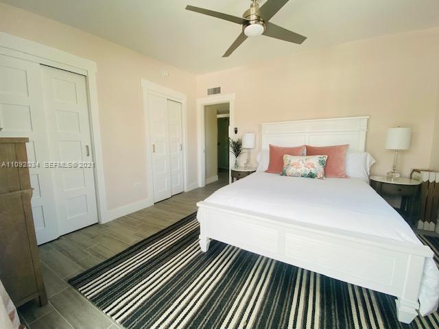 203 Atlantic Boulevard, Unit 203 Key Largo, FL 33037 - Photo 30 of 41 a bedroom with a bed and wooden floor