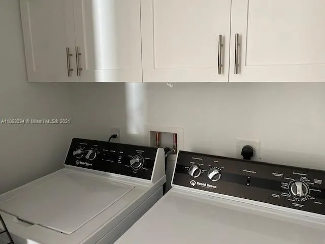 a kitchen with white cabinets and black appliances