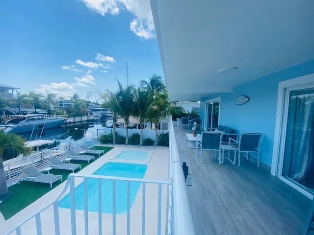 a view of a patio with table and chairs with wooden floor and fence