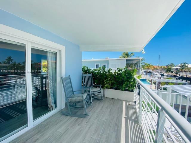 203 Atlantic Boulevard, Unit 203 Key Largo, FL 33037 - Photo 10 of 41 a balcony with chairs and wooden floor