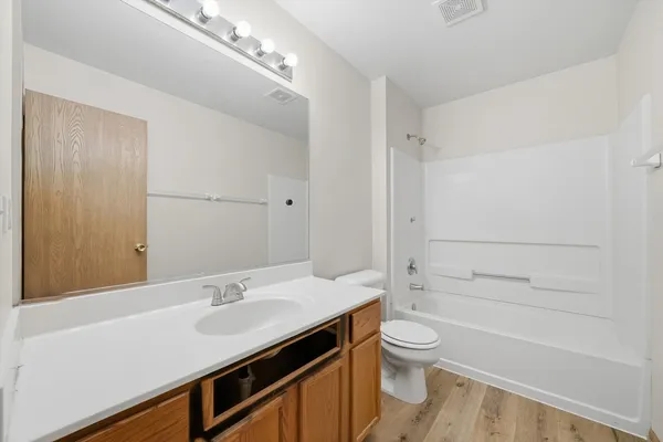 a bathroom with a sink a toilet and a large mirror