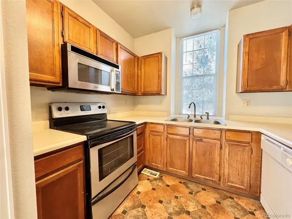 a kitchen with stainless steel appliances granite countertop a sink stove and microwave