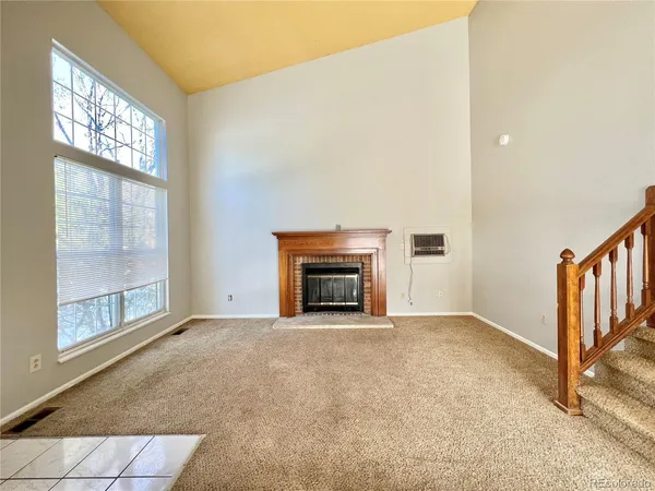 a view of an empty room with a fireplace and a window