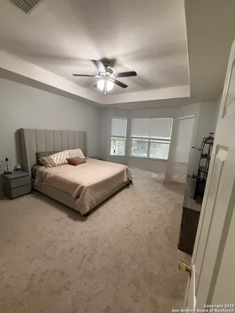 a bedroom with a bed and a ceiling fan