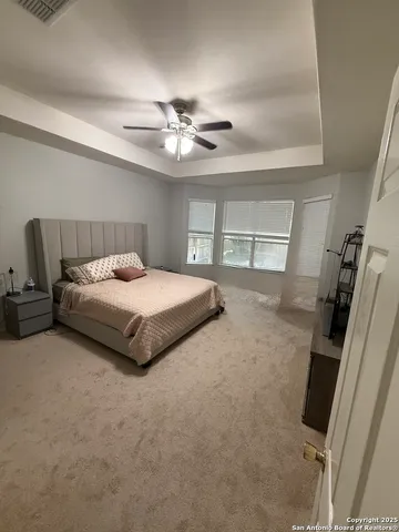 a bedroom with a bed and a ceiling fan