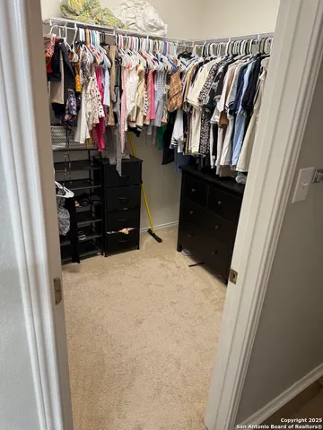a view of walk in closet with clothes and shoes