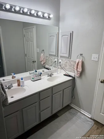 a bathroom with a double vanity sink and a mirror