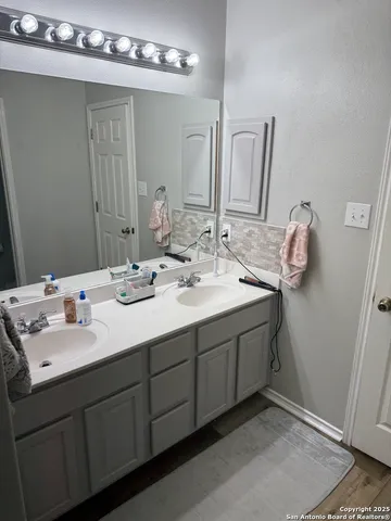 a bathroom with a double vanity sink and a mirror