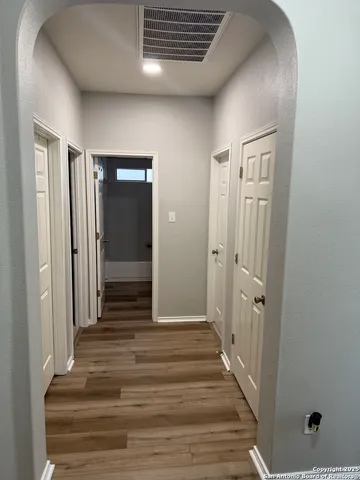 a view of a hallway with wooden floor and closet