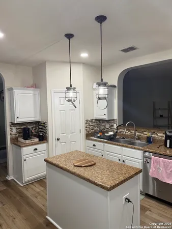 a kitchen with kitchen island a sink stove and refrigerator