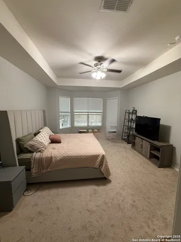 a spacious bedroom with a bed and a chandelier