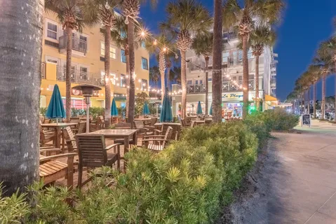 a view of a patio with a table and chairs under an umbrella with a small yard