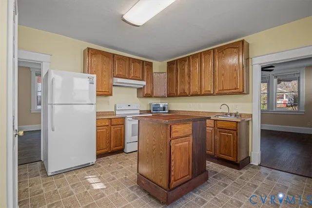 a kitchen with a refrigerator sink and cabinets