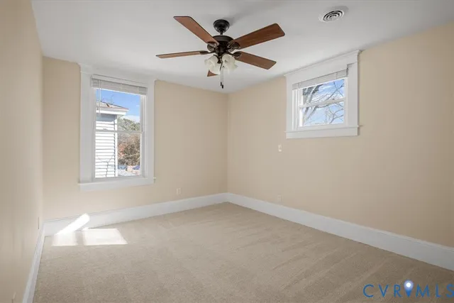 an empty room with a window and a ceiling fan