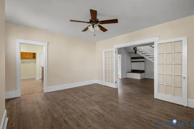 a view of empty room with wooden floor and ceiling fan