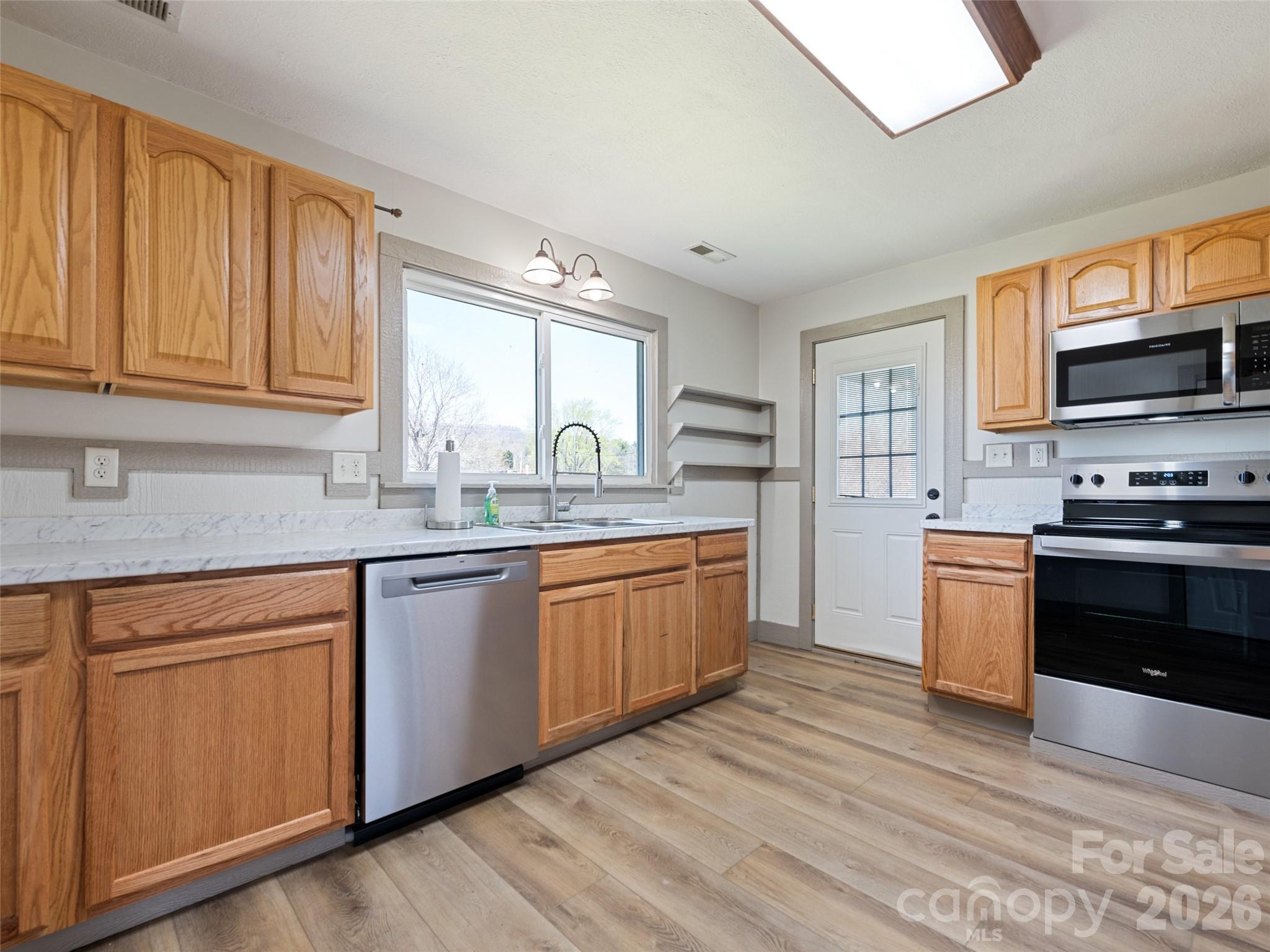 13 Depot Street Clyde, NC 28721 - Photo 10 of 21 a kitchen with stainless steel appliances granite countertop a stove a sink and a microwave