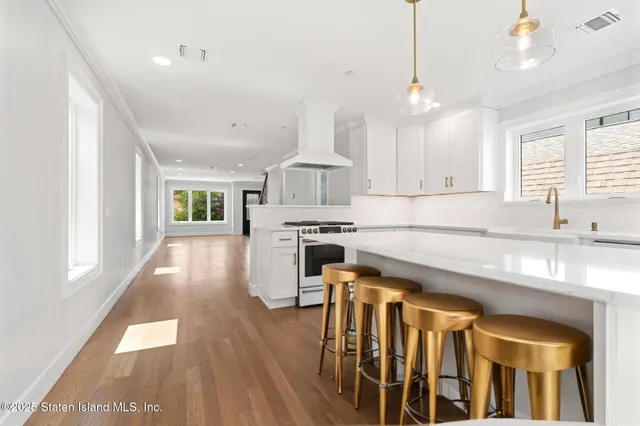 a kitchen with wooden floor and windows