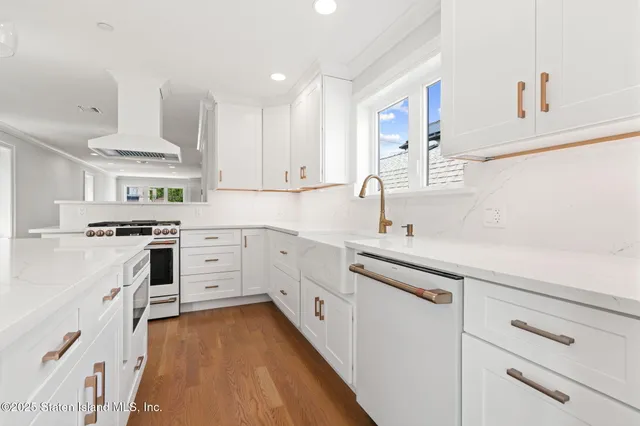 a kitchen with white cabinets appliances and a sink