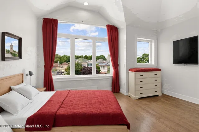 a bedroom with a bed and a flat screen tv