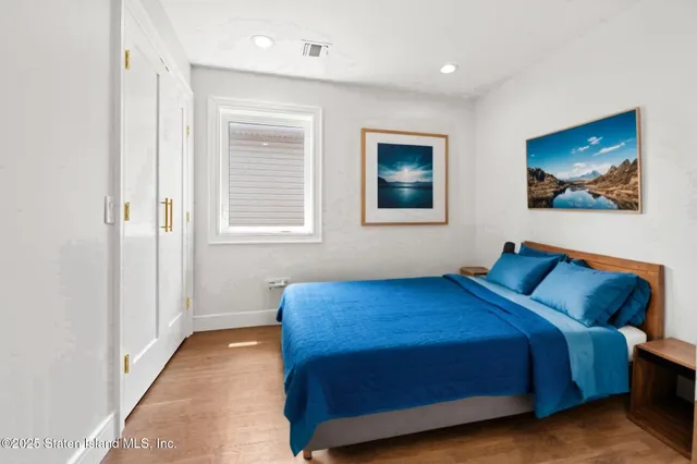 a bedroom with a bed and a painting on the wall