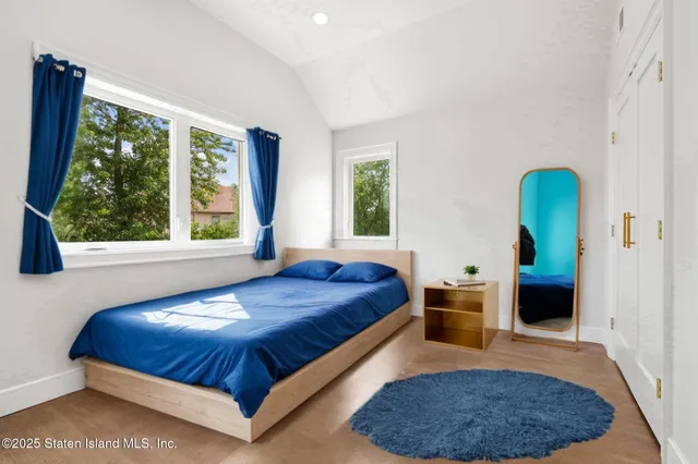 a spacious bedroom with a bed a table and windows