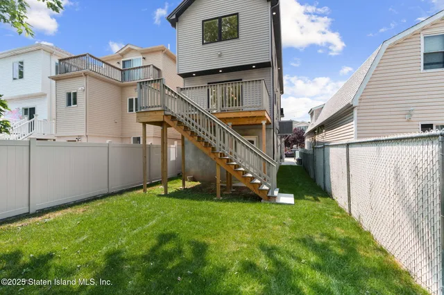 a view of an house with backyard and fence