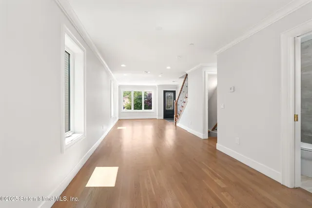a view of a big room with wooden floor and windows