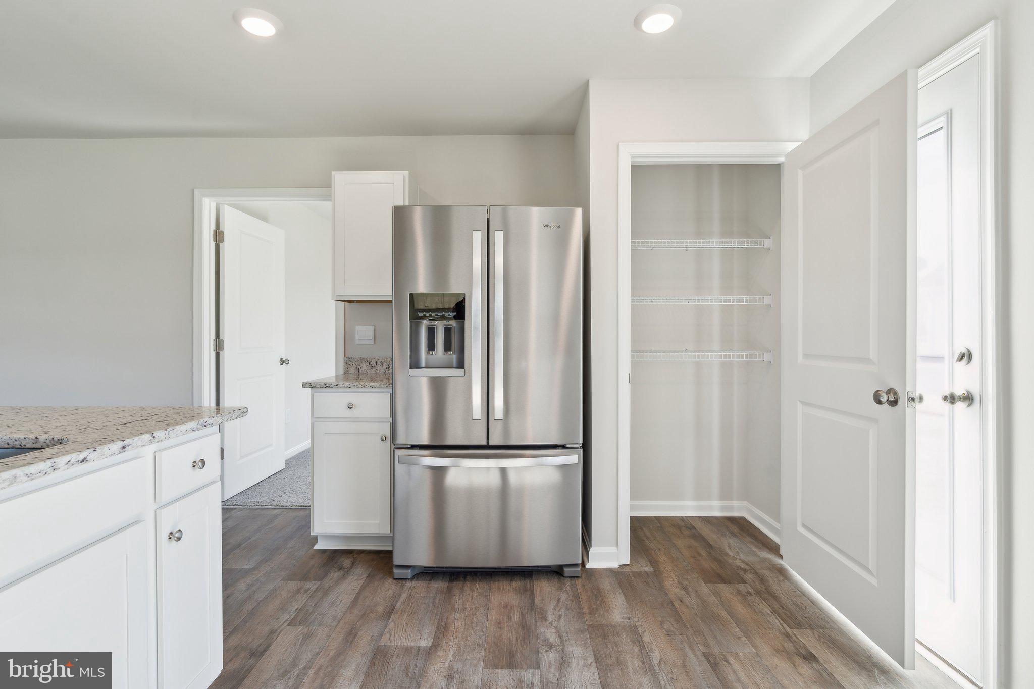 132 Hobbs Street Greensboro, MD 21639 - Photo 10 of 20 a kitchen with kitchen island wooden floor white refrigerator and cabinets