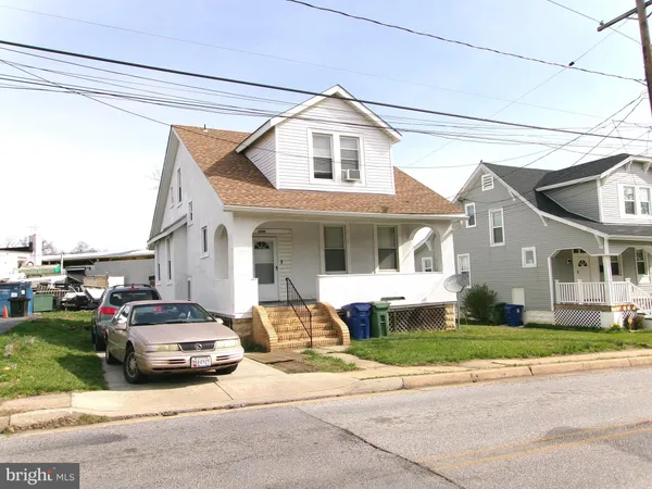 a front view of a house with a garden and plants
