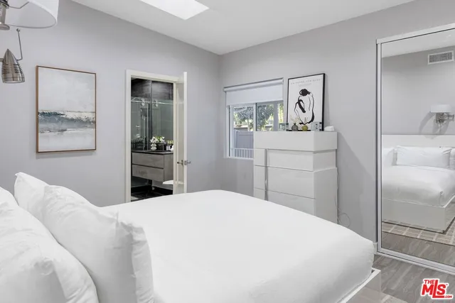 a bedroom with a bed and a painting on the wall