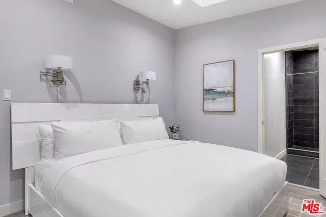 a bedroom with a large bed and a chandelier