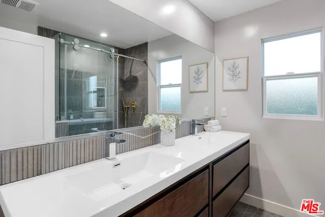 a bathroom with a double vanity sink mirror and a bathtub
