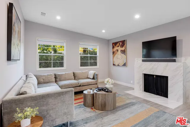a living room with fireplace furniture and a flat screen tv
