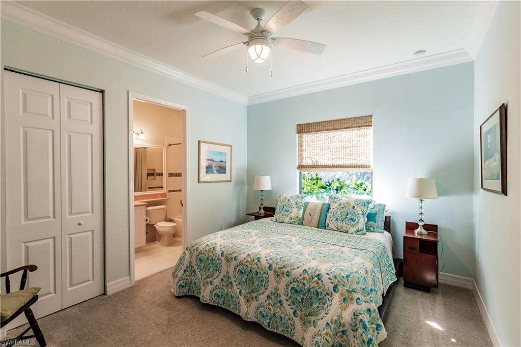 3432 Atlantic Circle Naples, FL 34119 - Photo 17 of 31 a bedroom with a bed and a chandelier