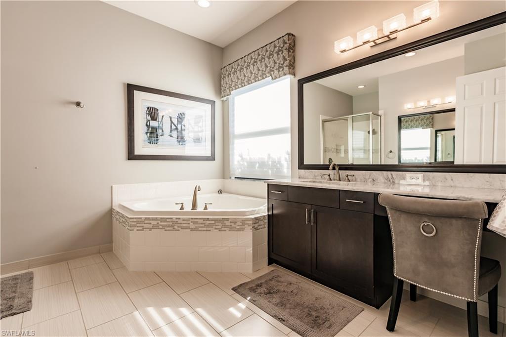 3432 Atlantic Circle Naples, FL 34119 - Photo 20 of 31 a bathroom with a bathtub sink and a mirror