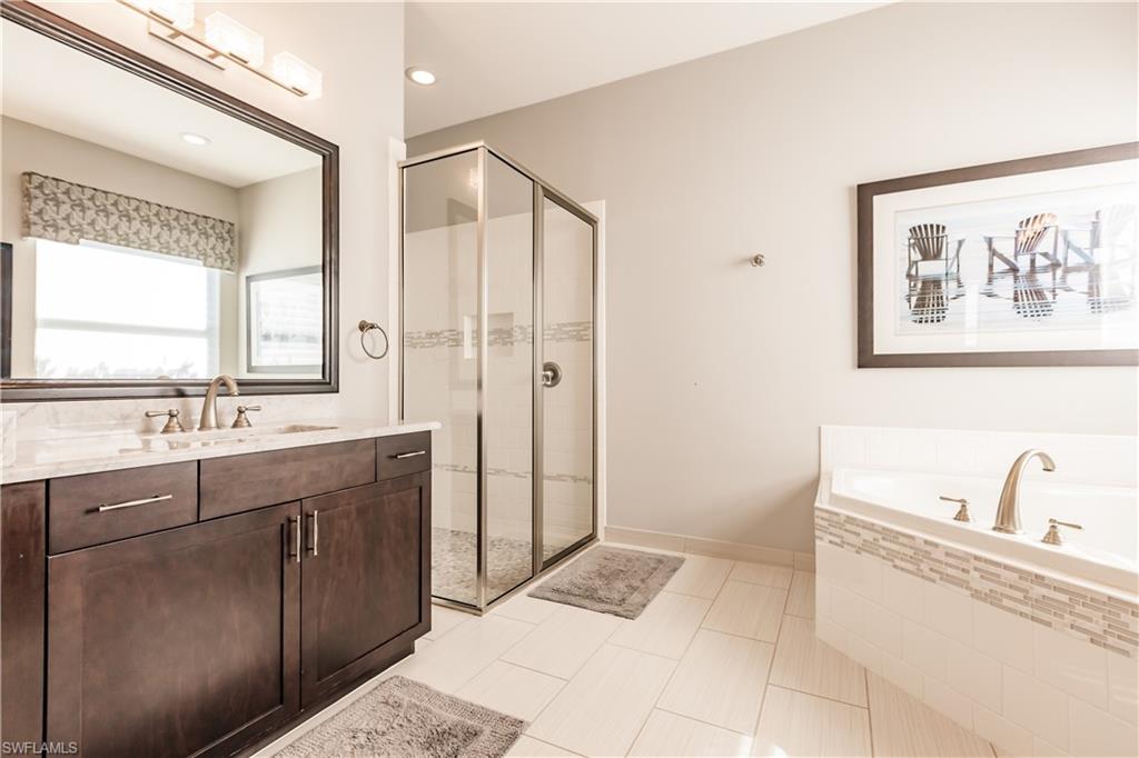3432 Atlantic Circle Naples, FL 34119 - Photo 21 of 31 a spacious bathroom with a tub sink and mirror