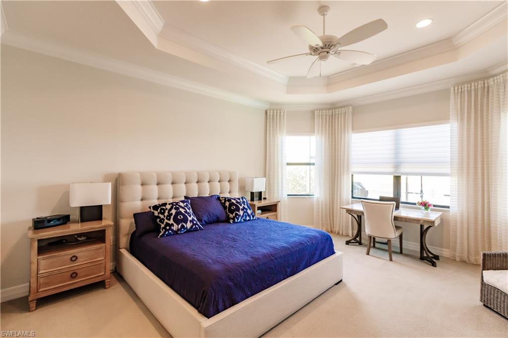 3432 Atlantic Circle Naples, FL 34119 - Photo 22 of 31 a bedroom with a bed and a chandelier