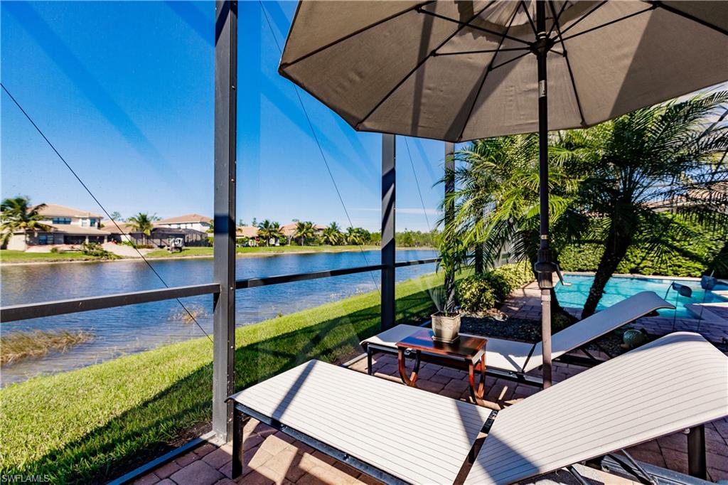 3432 Atlantic Circle Naples, FL 34119 - Photo 30 of 31 a view of a patio with table and chairs under an umbrella