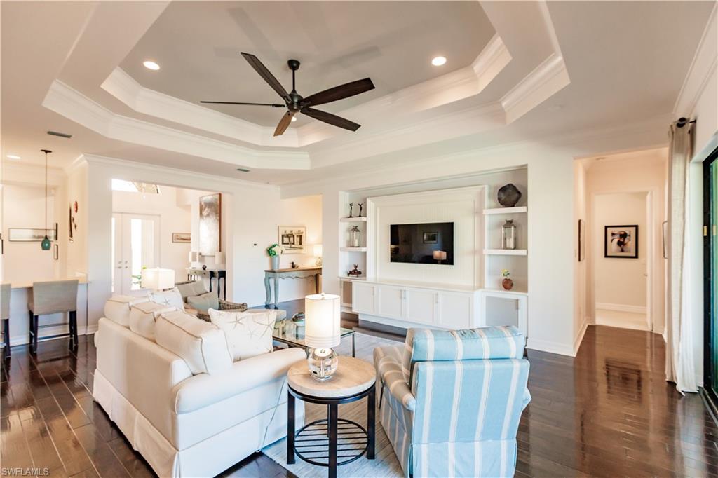 3432 Atlantic Circle Naples, FL 34119 - Photo 5 of 31 a living room with furniture a flat screen tv and a fireplace