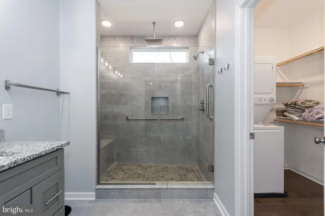 a bathroom with a granite countertop shower a sink and a mirror