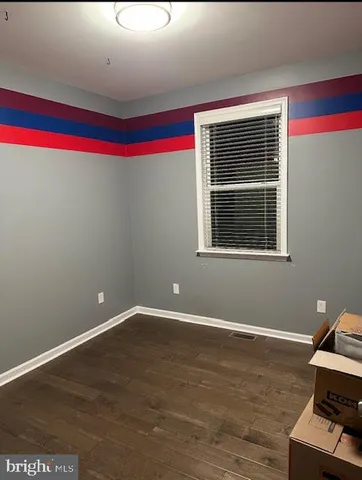 a room with wooden floor and windows
