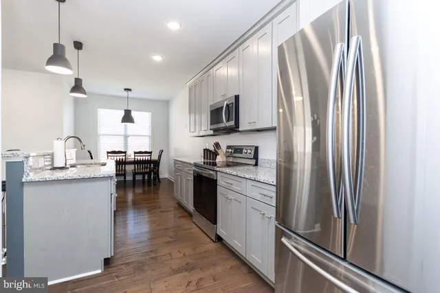 a kitchen with stainless steel appliances granite countertop a refrigerator sink and stove