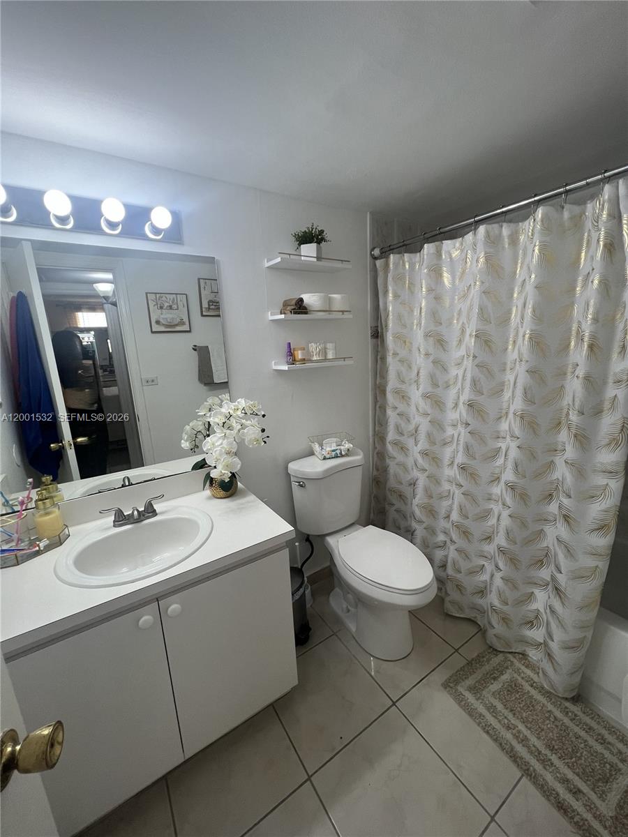 666 West 81st Street, Unit 407 Hialeah, FL 33014 - Photo 7 of 9 a bathroom with a sink a toilet and mirror