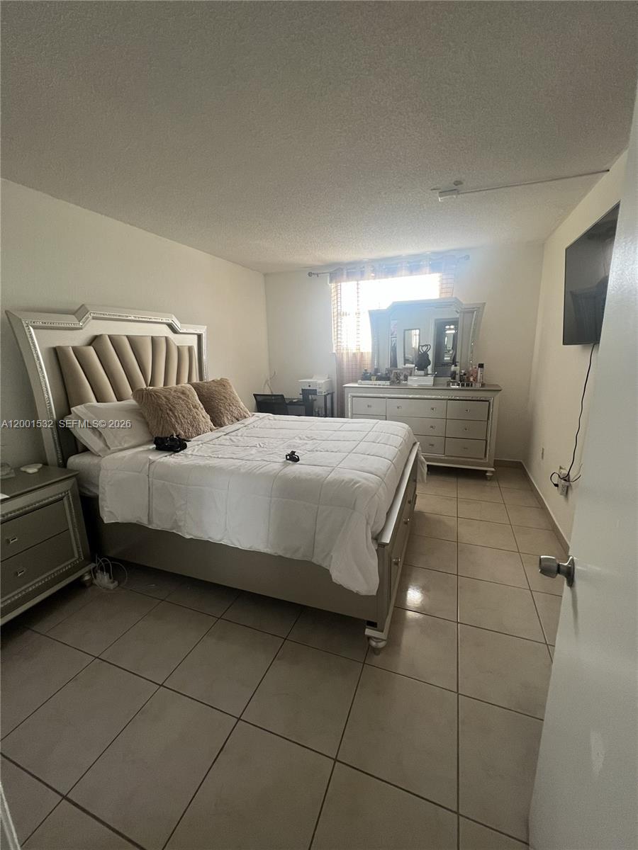 666 West 81st Street, Unit 407 Hialeah, FL 33014 - Photo 8 of 9 a bedroom with a bed and furniture