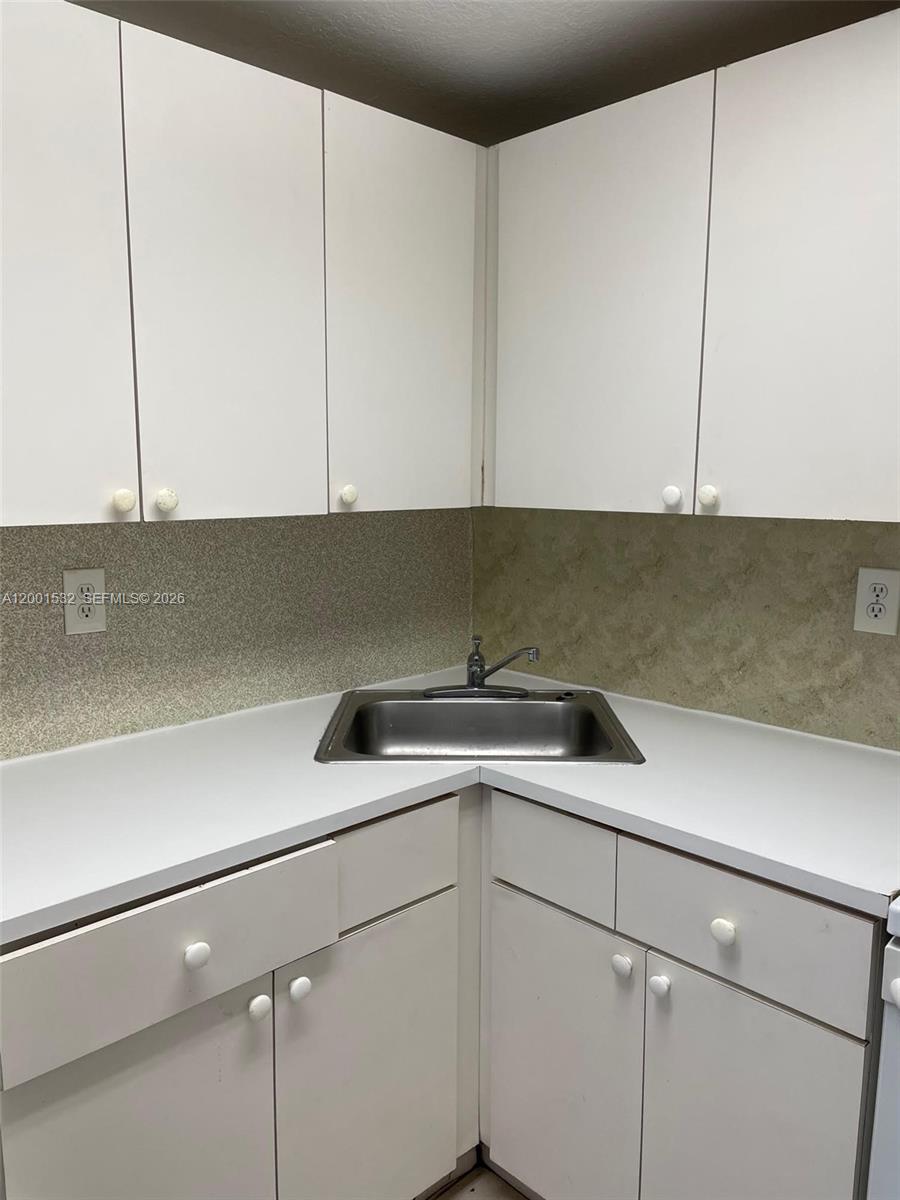666 West 81st Street, Unit 407 Hialeah, FL 33014 - Photo 9 of 9 a kitchen with a sink and cabinets