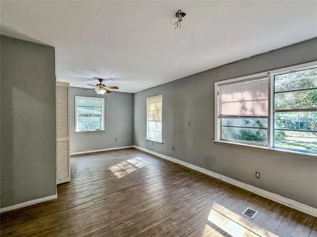 a view of empty room with wooden floor