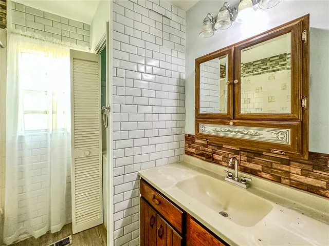 an empty room with a window and a ceiling fan