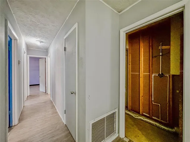 an empty room with wooden floor and cabinet