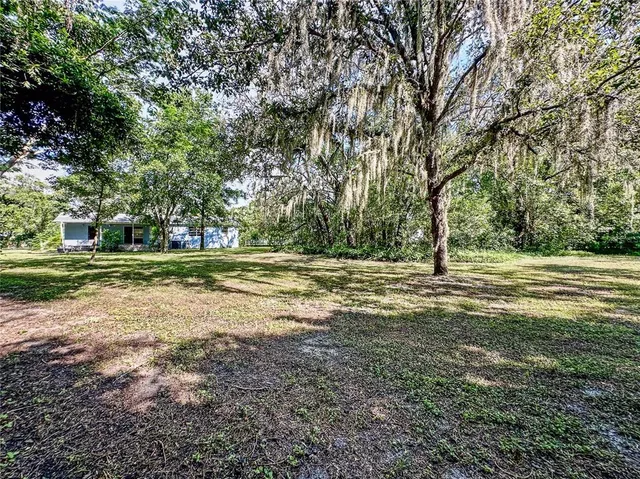 a view of a chairs in the patio next to a yard