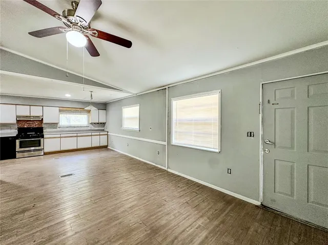 a kitchen with stainless steel appliances granite countertop a stove a sink and a microwave